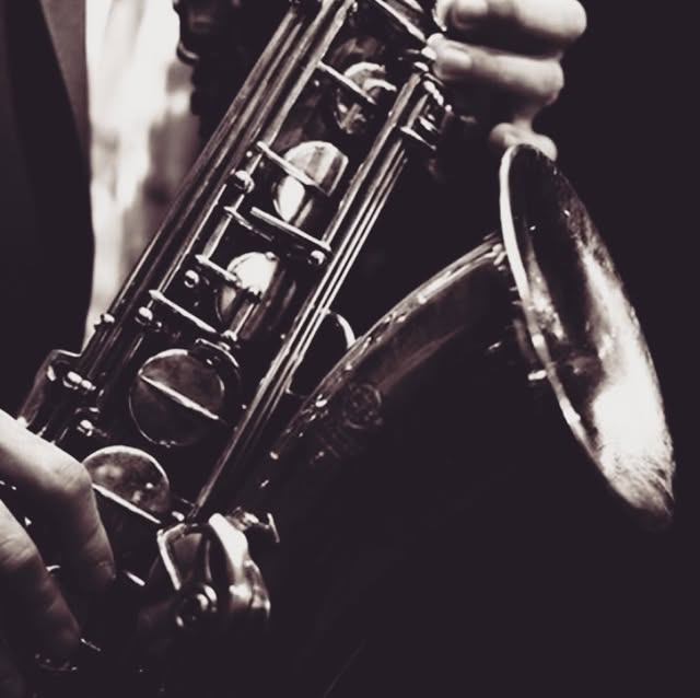 A musician playing saxophone during a live music night at The Press